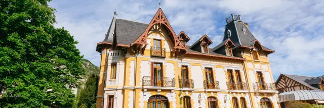 Elegant manor with intricate architectural details and a large garden