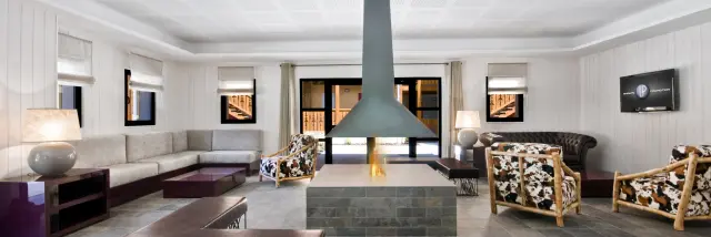 Modern living room with central fireplace, sofas and armchairs