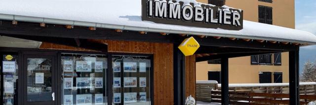 Real estate agency with listings in the windows, under the snow