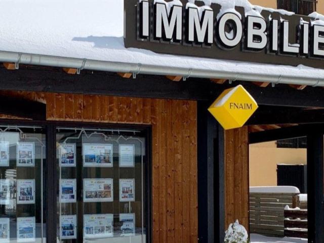 Real estate agency with listings in the windows, under the snow