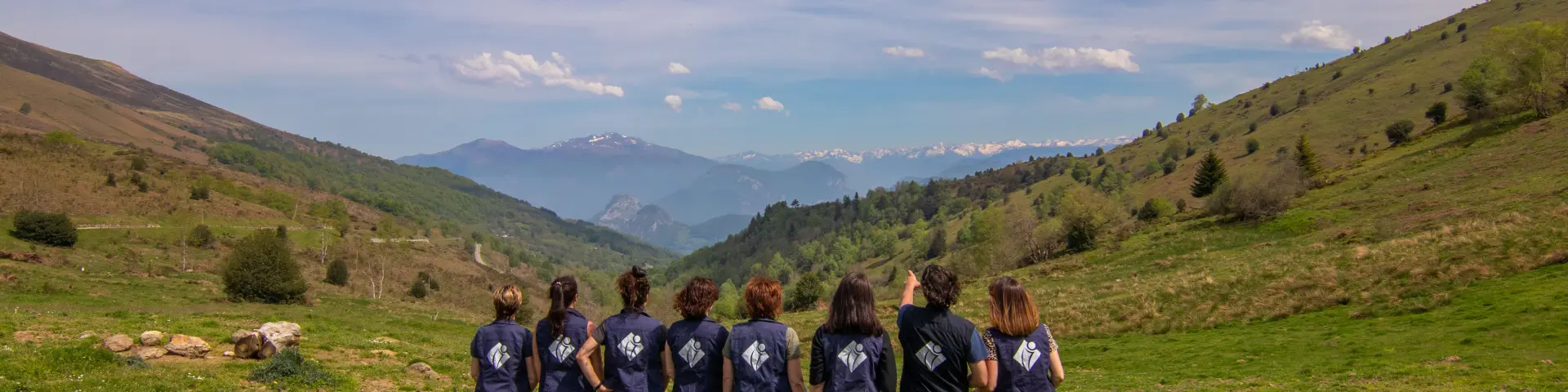 A group of people hiking in a green valley