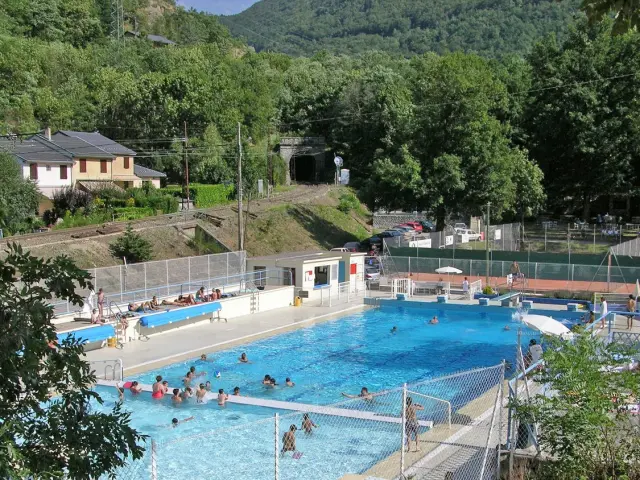 Outdoor swimming pool with people swimming and relaxing