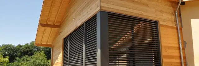 Wooden house with a large wooden terrace and closed shutters