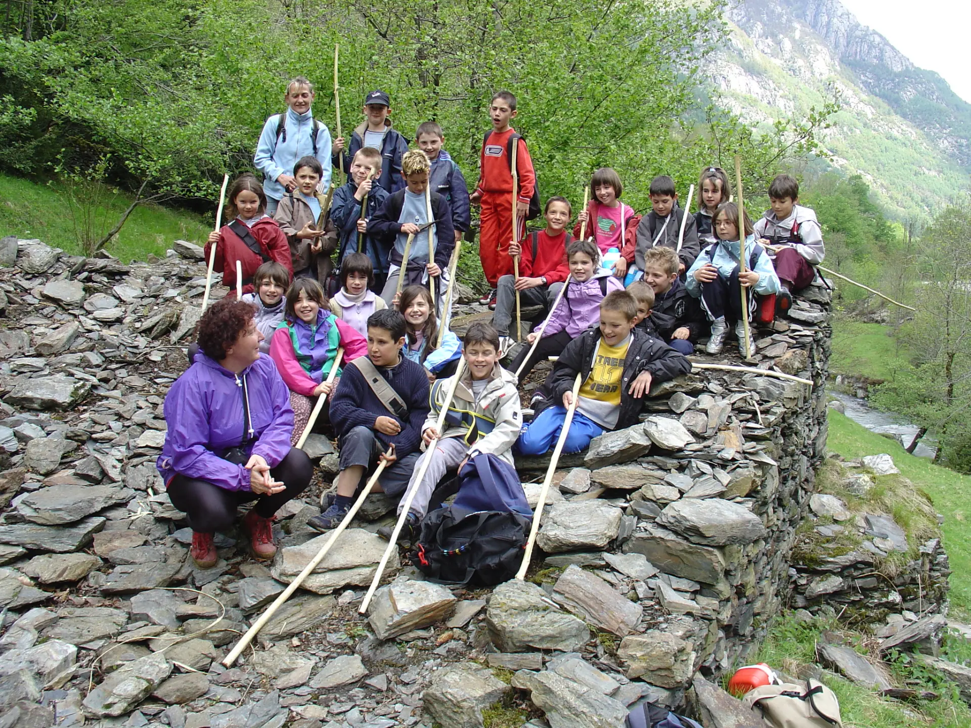 Group of children and adults hiking with sticks