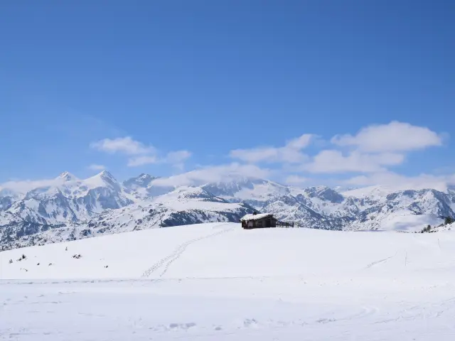 Wooden cabin in the middle of a snowy mountainous landscape