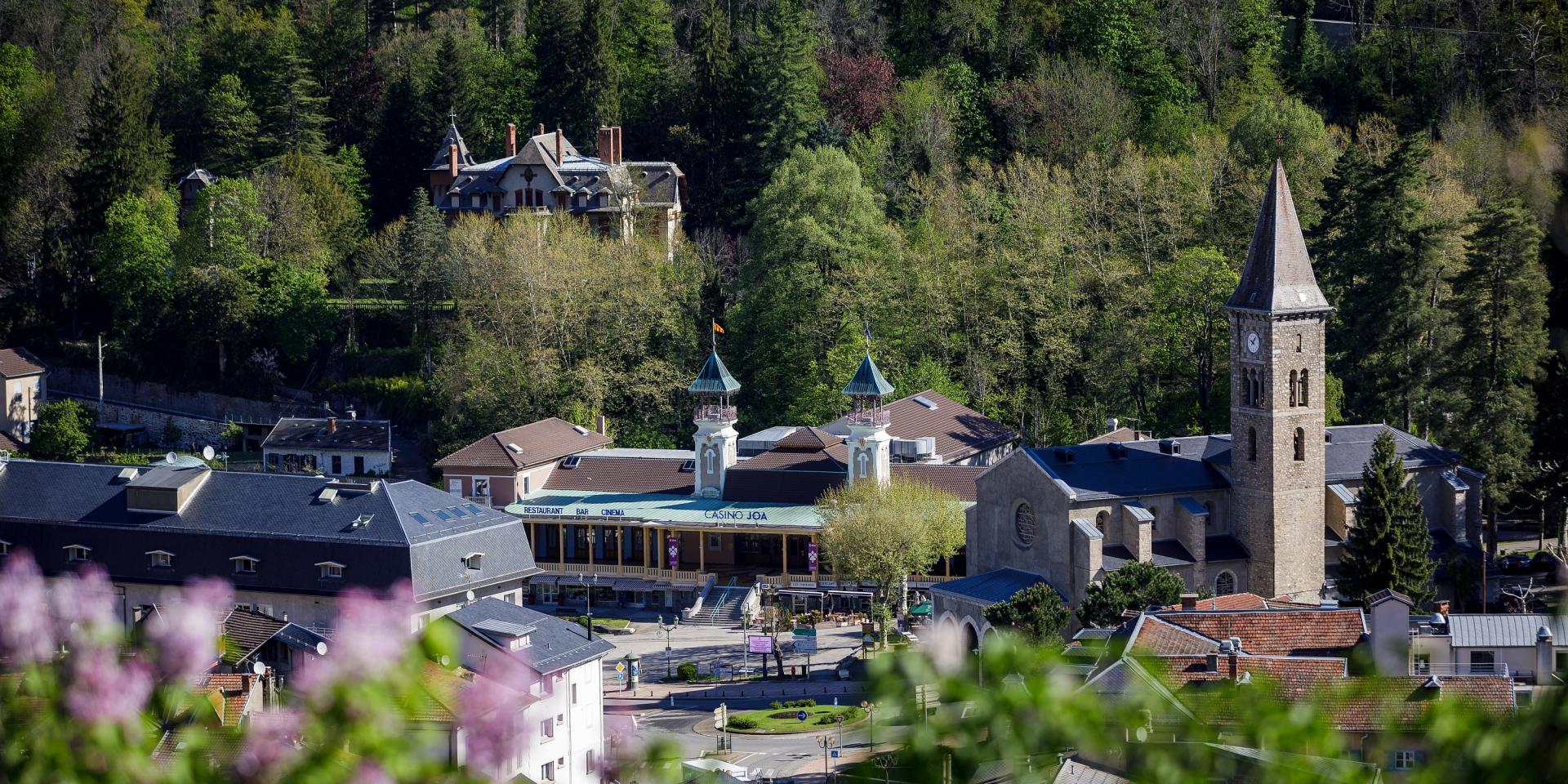 Mountain village with a church and houses surrounded by trees