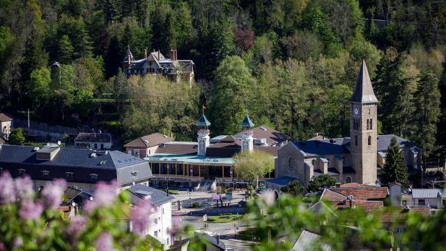 Mountain village with a church and houses surrounded by trees