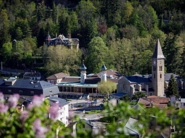 Pueblo de montaña con una iglesia y casas rodeadas de árboles