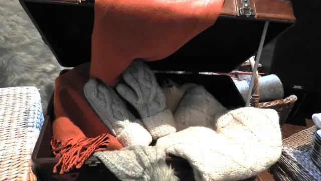 Un coffre en bois rempli de gants, d'écharpes et d'un bonnet