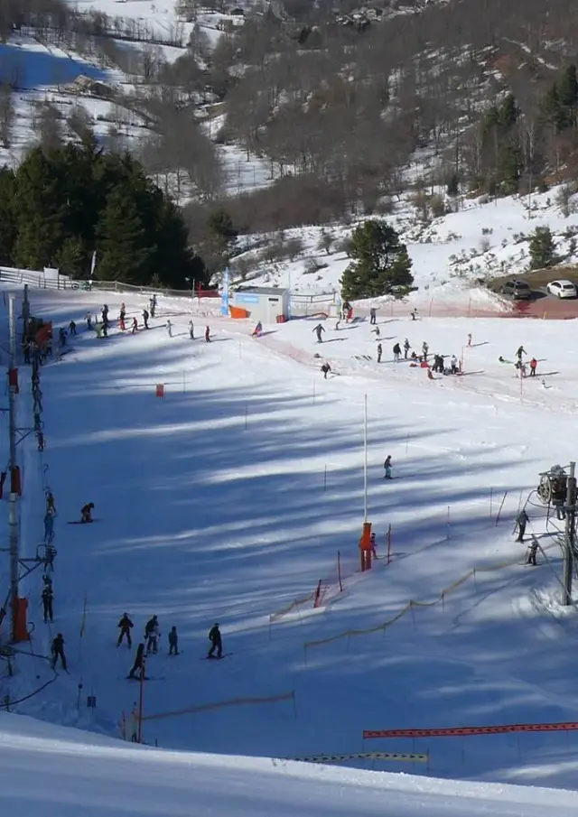 Piste de ski avec des skieurs et des débutants sur des tapis roulants