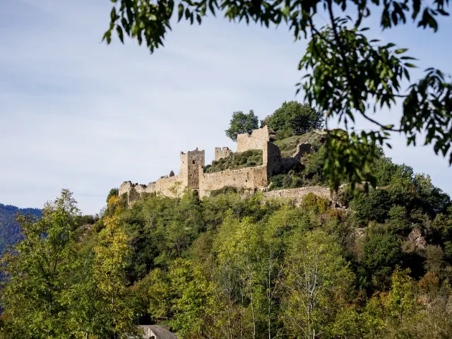 Château médiéval en pierre sur une colline verdoyante
