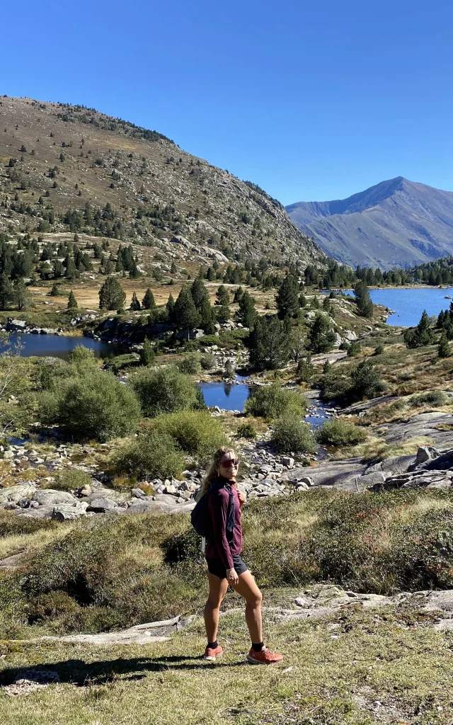 Une personne marchant dans une vallée montagneuse avec des lacs