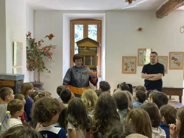 A group of children listening to a story in a room with wall decorations