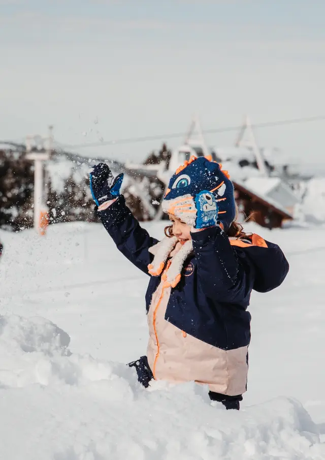 Enfant habillé chaudement jouant dans la neige avec des gants et une écharpe