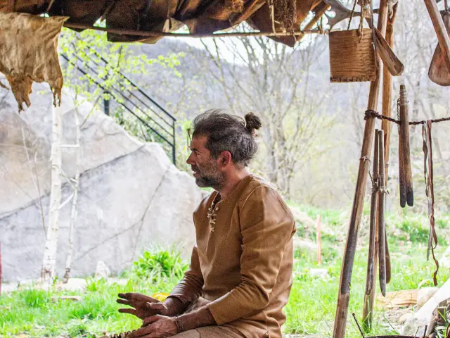 Un artisan traditionnel travaille sous un abri en paille