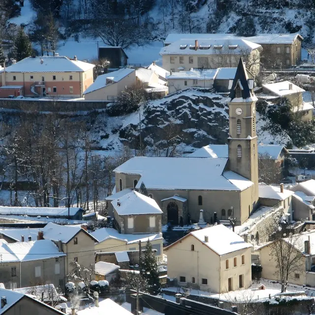 Vue aérienne d'un village enneigé avec une église au centre