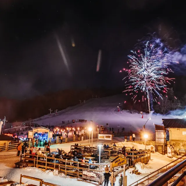 Feu d'artifice illuminant une station de ski de nuit